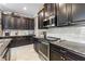 Modern kitchen with stainless steel appliances, granite countertops, and dark cabinetry, offering both style and functionality at 16898 Balance Cv, Land O Lakes, FL 34638