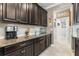 Well-appointed kitchen with dark cabinets, granite countertops, and stainless steel appliances that provide a modern aesthetic at 16898 Balance Cv, Land O Lakes, FL 34638