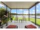 Enclosed lanai featuring outdoor seating and peaceful waterfront views for relaxation and entertainment at 16898 Balance Cv, Land O Lakes, FL 34638