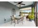 Cozy outdoor lanai with ceiling fan, glass top table, chairs, and plants for relaxing and enjoying outdoor living at 16898 Balance Cv, Land O Lakes, FL 34638