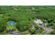 An aerial view displays a clubhouse and pool area surrounded by greenery and trees at 17203 Talence Ct, Tampa, FL 33647