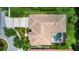 An aerial view showcases a tan-roofed home with a screened-in pool and lush landscaping at 17203 Talence Ct, Tampa, FL 33647