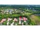 An aerial view highlights a tan-roofed home among landscaped yards in a neighborhood at 17203 Talence Ct, Tampa, FL 33647