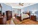 Comfortable bedroom with hardwood floors, a dark wood bed, side tables, and a sitting area by the window at 17203 Talence Ct, Tampa, FL 33647