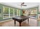 Spacious game room with a pool table, large windows, and an inviting view of the lush outdoors and pool at 17203 Talence Ct, Tampa, FL 33647