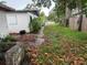Backyard concrete path featuring a damaged concrete block, debris and a parked car on the street in the distance at 1835 15Th S Ave, St Petersburg, FL 33712