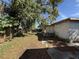 View of the backyard showing the ground covered in leaves and a building along the side at 1835 15Th S Ave, St Petersburg, FL 33712