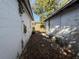 Backyard view between two white detached buildings, with foliage and scattered debris at 1835 15Th S Ave, St Petersburg, FL 33712