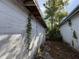 Exterior side view of the house showing peeling paint and vegetation growing on the side at 1835 15Th S Ave, St Petersburg, FL 33712
