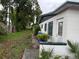 View of the side of the building with a lawn, trees, and a door at 1835 15Th S Ave, St Petersburg, FL 33712