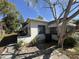 Exterior angle of home showcasing white siding, mature trees and back door at 1835 15Th S Ave, St Petersburg, FL 33712