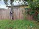 Side yard with wooden fence and overgrown foliage at 1835 15Th S Ave, St Petersburg, FL 33712