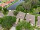 Aerial view of multiple homes with well maintained lawns and neutral-toned roofs near a lush pond at 19204 Weymouth Dr, Land O Lakes, FL 34638