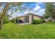 Backyard patio with seating and grill, surrounded by green grass and landscaping at 19204 Weymouth Dr, Land O Lakes, FL 34638