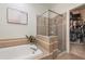 Bathroom featuring tub, glass-enclosed shower, and access to a walk-in closet at 19204 Weymouth Dr, Land O Lakes, FL 34638