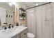 This well-lit bathroom includes a vanity with marble countertops and a shower with curtains at 19204 Weymouth Dr, Land O Lakes, FL 34638