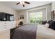 Bedroom with a large window, dresser, and a modern armchair and floor lamp at 19204 Weymouth Dr, Land O Lakes, FL 34638