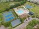 Aerial shot of a community center, showcasing tennis courts, a playground, and a swimming pool at 19204 Weymouth Dr, Land O Lakes, FL 34638