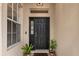 Close-up of the front door with decorative plants and a welcome mat at 19204 Weymouth Dr, Land O Lakes, FL 34638