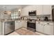 Bright kitchen featuring white cabinets, stainless steel appliances, and stylish decor at 19204 Weymouth Dr, Land O Lakes, FL 34638