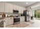 Well-equipped kitchen with white cabinetry and stainless steel appliances at 19204 Weymouth Dr, Land O Lakes, FL 34638
