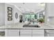 Modern kitchen features white cabinets, granite countertops and stainless steel sink overlooking the living area at 20025 Callisto Hill Pl, Tampa, FL 33647