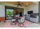 Covered lanai featuring an outdoor dining area and comfortable seating with sliding door access at 20025 Callisto Hill Pl, Tampa, FL 33647