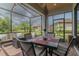 Enclosed lanai offers comfortable seating and dining area with views of the landscaped backyard at 20025 Callisto Hill Pl, Tampa, FL 33647