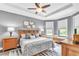 Comfortable main bedroom features a tray ceiling, neutral colors, and an abundance of natural light at 20025 Callisto Hill Pl, Tampa, FL 33647