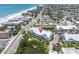 Aerial view of coastal home near the beach with mature trees and small pond at 204 Haven Beach Ct, Indian Rocks Beach, FL 33785