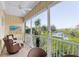 Relaxing screened balcony with comfortable wicker seating offers serene views of the waterway and lush foliage at 204 Haven Beach Ct, Indian Rocks Beach, FL 33785