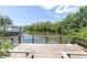 Wooden dock with seating area overlooking waterfront and nearby boat dock at 204 Haven Beach Ct, Indian Rocks Beach, FL 33785
