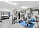 Spacious garage equipped as a home gym with exercise equipment and parking for a white car at 204 Haven Beach Ct, Indian Rocks Beach, FL 33785