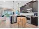 Contemporary kitchen featuring dark wood cabinets, stainless steel appliances, and a view of the living area at 204 Haven Beach Ct, Indian Rocks Beach, FL 33785