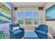 Inviting living room with comfortable blue armchairs, ottoman, and bright window views at 204 Haven Beach Ct, Indian Rocks Beach, FL 33785
