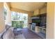 Outdoor kitchen with stainless steel grill, sink, bar seating, and brick floors at 204 Haven Beach Ct, Indian Rocks Beach, FL 33785