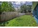 This spacious backyard has a well-maintained lawn, a wooden privacy fence, and a mature tree at 2307 N 47Th St, Tampa, FL 33605