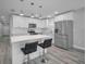 Modern kitchen with white cabinets, stainless steel appliances, and a quartz island with bar stools at 2307 N 47Th St, Tampa, FL 33605