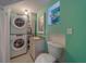 Inviting bathroom with stacked washer-dryer and a sink with a large window at 2412 Burlington N Ave, St Petersburg, FL 33713