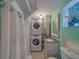 Cozy bathroom featuring stackable washer and dryer and bright, mint-green walls at 2412 Burlington N Ave, St Petersburg, FL 33713