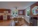 Sunlit dining area with white table for four, a decorative mirror, and views to the kitchen and backyard at 2412 Burlington N Ave, St Petersburg, FL 33713