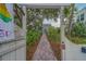 Inviting walkway leading to a charming home, framed by lush greenery and an arbor with visible address at 2412 Burlington N Ave, St Petersburg, FL 33713