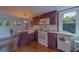 Bright kitchen featuring plum cabinetry, granite countertops, and a large farmhouse sink with modern appliances at 2412 Burlington N Ave, St Petersburg, FL 33713