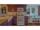 Inviting kitchen featuring plum-colored cabinets, granite countertops, a farmhouse sink, and modern appliances at 2412 Burlington N Ave, St Petersburg, FL 33713