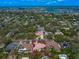 Aerial view showcases a home nestled in a neighborhood with trees and other properties in the distance at 307 Palmetto Ln, Largo, FL 33770