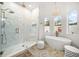 Bright bathroom with freestanding tub, glass shower, and decorative light fixture at 307 Palmetto Ln, Largo, FL 33770