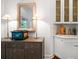 Close-up of built-in bar featuring custom cabinets, decorative mirror, and elegant lighting at 307 Palmetto Ln, Largo, FL 33770