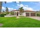 Elegant home featuring a lush green lawn and a clay tile roof with a two-car garage at 307 Palmetto Ln, Largo, FL 33770
