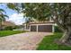 Home with a red tile roof, a two-car garage, and a circular brick driveway at 307 Palmetto Ln, Largo, FL 33770