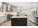 Bright kitchen with stainless steel appliances, a large island, and custom cabinetry at 307 Palmetto Ln, Largo, FL 33770